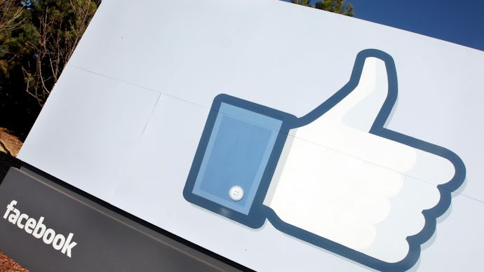 the facebook logo beneath a large sign with the like button on it