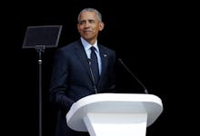 Barack Obama wearing a suit while giving a speech