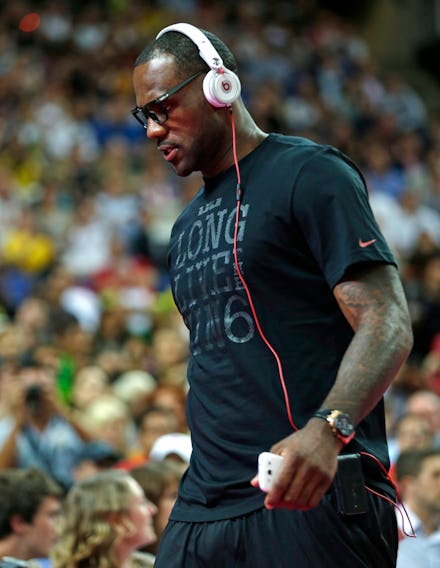 LeBron James with white Beats headphones in a black shirt walking on the basketball court