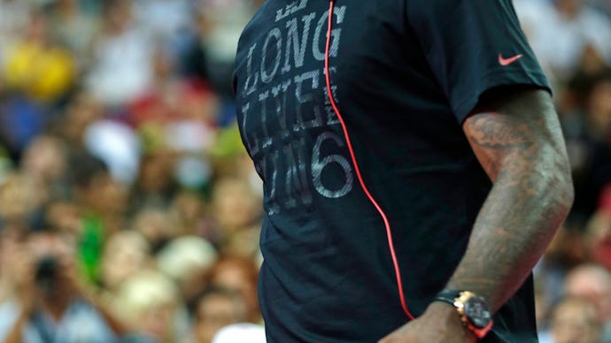 LeBron James with white Beats headphones in a black shirt walking on the basketball court