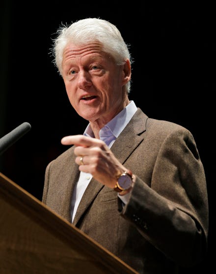 Bill Clinton giving his opinions on Obamacare at a podium with a microphone, pointing his index fing...