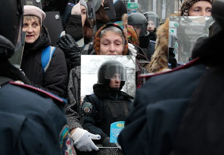 Ukranian protestor holds up a mirror to the police in riot gear