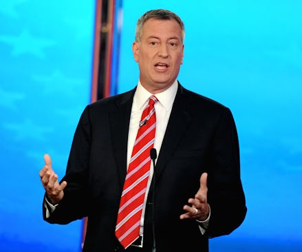 Bill de Blasio in a suit and red striped tie during a debate