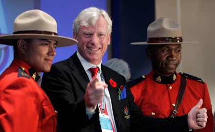 Bill de Blasio giving a thumbs up and pointing while standing next to two canadian mounties