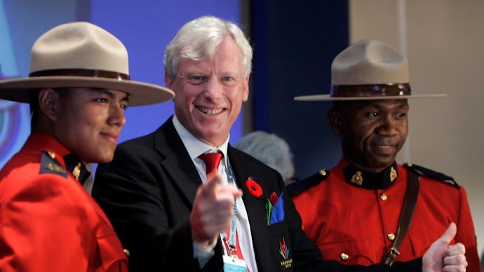 Bill de Blasio giving a thumbs up and pointing while standing next to two canadian mounties