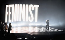 Beyoncé performing at the 2014 VMAs with the word "feminist" lit up behind her