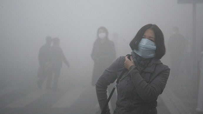 A woman with a mask covering her face due to suffocating pollution, walking down a street in China
