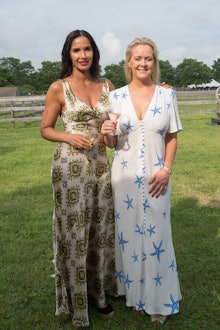A woman in a green-white long floral dress, and a woman in a white dress with blue stars at the Jame...