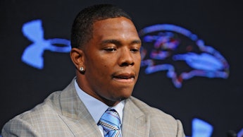 Ray Rice in a grey blazer, white shirt, and a blue-beige tie
