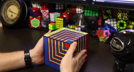 A man holding the world's largest Rubik's cube