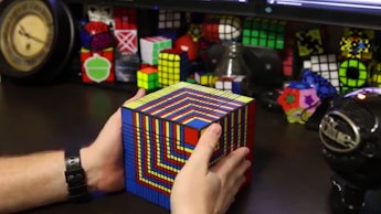 A man holding the world's largest Rubik's cube
