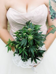 A woman wearing a wedding dress and holding a bouquet of marijuana at her weed wedding