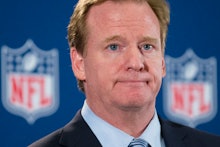 Roger Goodell standing in front of two NFL logos