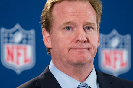 Roger Goodell standing in front of two NFL logos