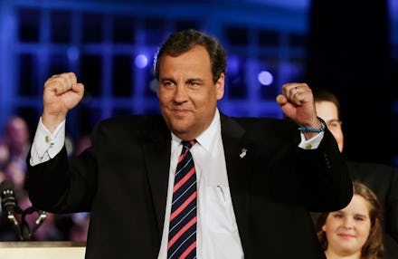 Chris Christie holding his fists up and smiling at a political rally