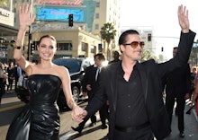 Angelina Jolie and Brad Pitt holding hands and waving at a crowd