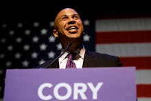 Cory booker giving a speech in front of an american flag