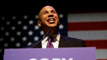 Cory booker giving a speech in front of an american flag