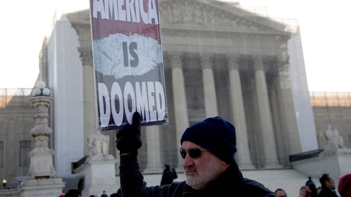 Protestor holding a sign that says America is doomed
