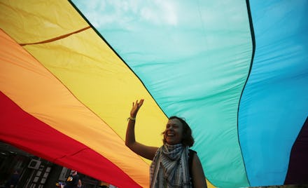 A woman walking underneath a large pride flag