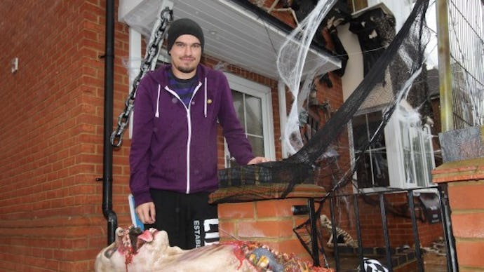 A man with his Halloween decorations featuring a very realistic rotting dead body 