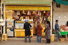 People of mixed age groups and gender, hanging out in front of a café in Iran