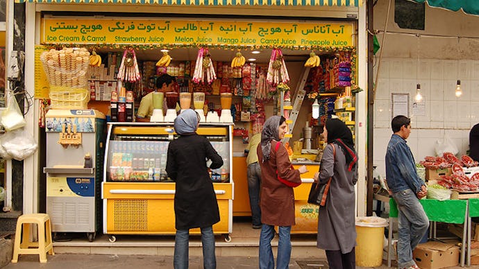 People of mixed age groups and gender, hanging out in front of a café in Iran