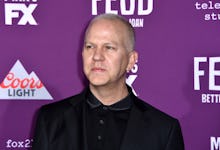 Ryan Murphy in a black shirt, and a black blazer at a red carpet event