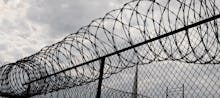 A wire fence around a prison building