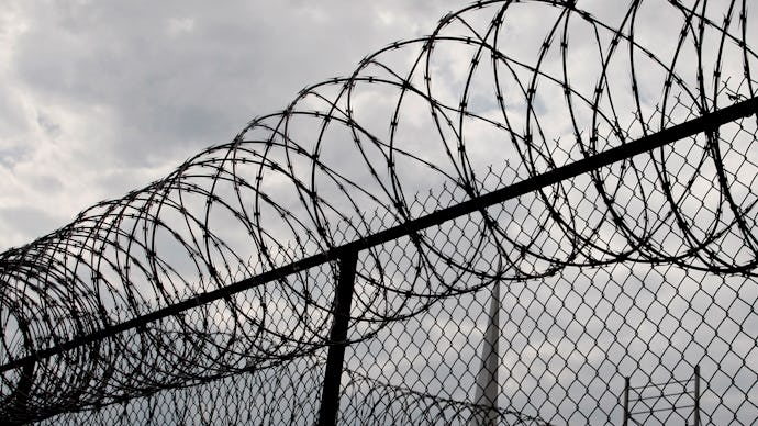 A wire fence around a prison building