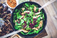 Spinach, chicken, pomegranate, and salad in a plate