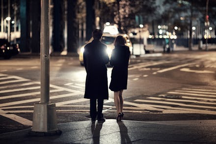 Two people standing on the street at the end of a date.