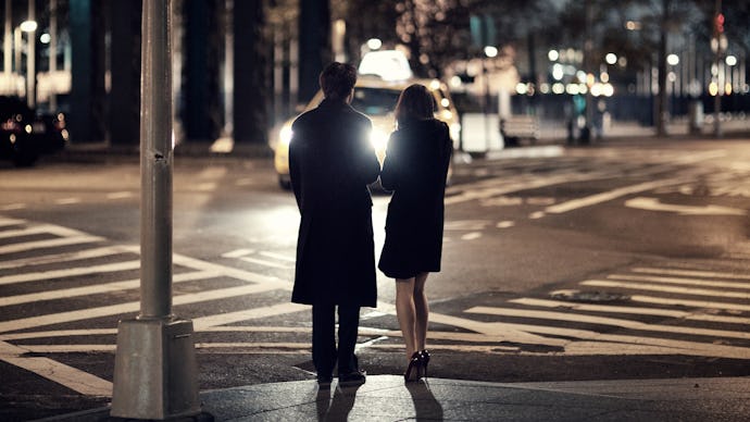 Two people standing on the street at the end of a date.