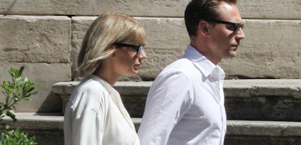 Taylor Swift and Tom Hiddleston walking down a street together