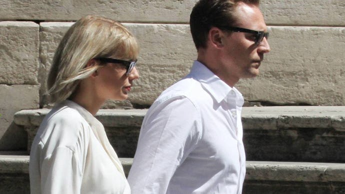 Taylor Swift and Tom Hiddleston walking down a street together