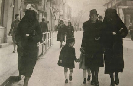 Muslim woman on the streets of Sarajevo, using her veil to cover her Jewish neighbor's yellow star i...