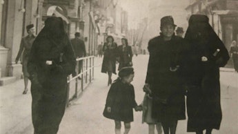 Muslim woman on the streets of Sarajevo, using her veil to cover her Jewish neighbor's yellow star i...
