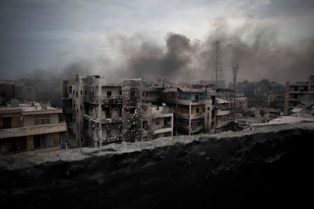 A row of building in Syria in ruins, smoke and fire