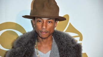 Pharrell Williams posing at the Grammy Awards with a brown hat