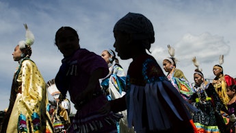 A group of Native Americans, who are considered to be a marginalized group walking down a street