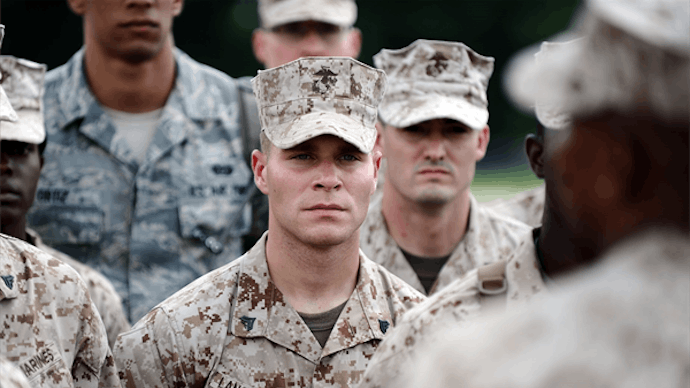 U.S. Marine Ryan Langenegger standing and listening to his instructor