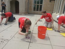 A group of people in red t-shirts cleaning the floor