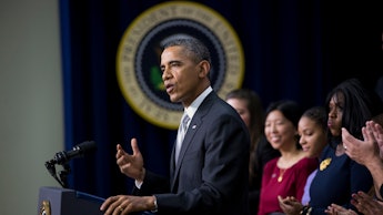 Barack Obama during a speech with a group of people standing behind him