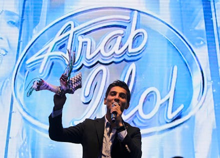 Palestinian Arab Idol singing with a microphone