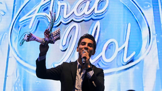 Palestinian Arab Idol singing with a microphone