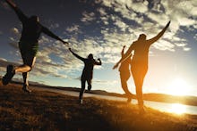 Four people happily jumping because they feel better and happier with a sunset in the background