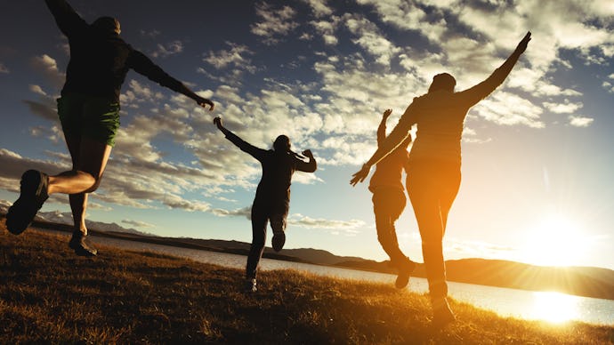 Four people happily jumping because they feel better and happier with a sunset in the background