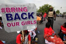  Protestors holding up signs to bring back the women and girls kidnapped by Boko Haram