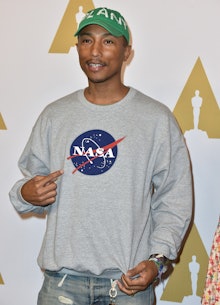 Pharrell Williams posing in a grey NASA sweatshirt