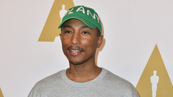 Pharrell Williams posing in a grey NASA sweatshirt
